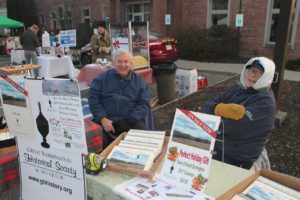 Shivering at the 2016 GB Holiday Stroll, archivist Gary Leveille (left) and executive director Bob Krol are selling the Society's 2017 Calendars. Photo by Lee Rogers.